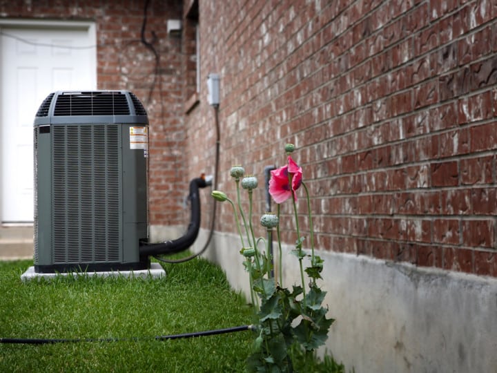 AC unit on a concrete pad on grass.