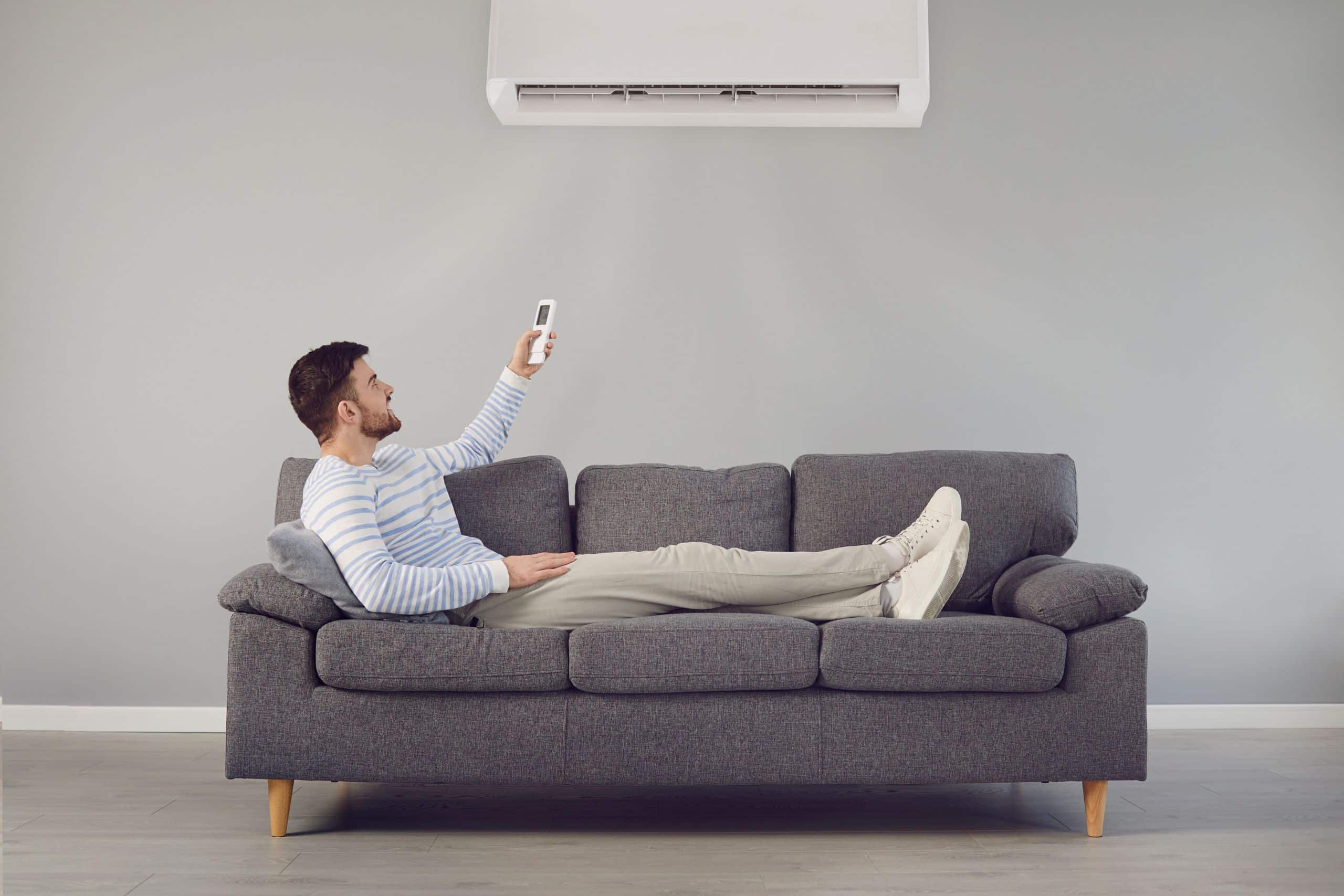Man relaxing on couch with with an upgraded air conditioning system in Colorado